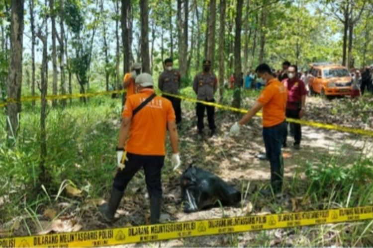 Polisi mengevakuasi mayat perempuan terbungkus kantong plastik hitam di kawasan hutan wilayah Dusun Besole, Desa Juworo, Kecamatan Geyer, Kabupaten Grobogan, Jawa Tengah, Rabu (13/10/2021).