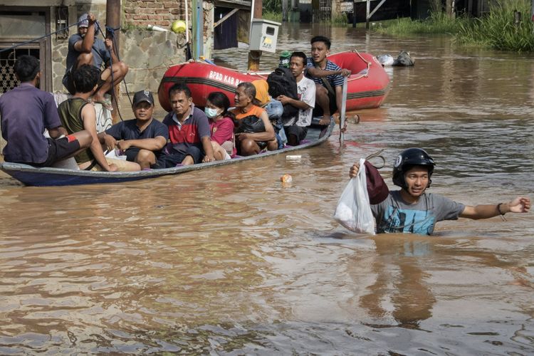 Warga melintasi genangan banjir untuk berevakuasi di  Dayeuhkolot, Kabupaten Bandung, Jawa Barat, Jumat (23/2). Sedikitnya 10 kecamatan di kawasan Bandung Selatan kembali dilanda Banjir setinggi 80 cm hingga 2 meter akibat luapan sungai Citarum dan intensitas curah hujan yang tinggi. ANTARA FOTO/Novrian Arbi/foc/18.