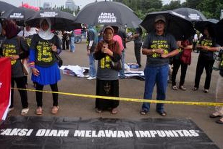 Sejumlah aktivis KontraS yang tergabung dalam Jaringan Solidaritas Korban untuk Keadilan (JSKK) melakukan aksi Kamisan ke-298 di depan Istana Merdeka, Jakarta Pusat, Kamis (21/3/2013). Aksi tersebut untuk kembali memberikan masukan dan desakan kepada Bapak Presiden atas lambannya penanganan peristiwa Pelanggaran HAM oleh pemerintah yang mengakibatkan keadilan dan kepastian hukum bagi korban menjadi terus terabaikan. Kamisan ini juga memperingati 15 tahun berdirinya Komisi untuk Orang Hilang & Korban Tindak Kekerasan (KontraS) pada 20 Maret, kemarin. 