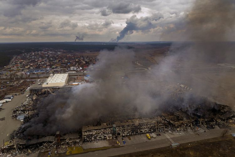 Sebuah pabrik dan toko terbakar setelah dibombardir di Irpin, di pinggiran Kyiv, Ukraina, Minggu, 6 Maret 2022. 