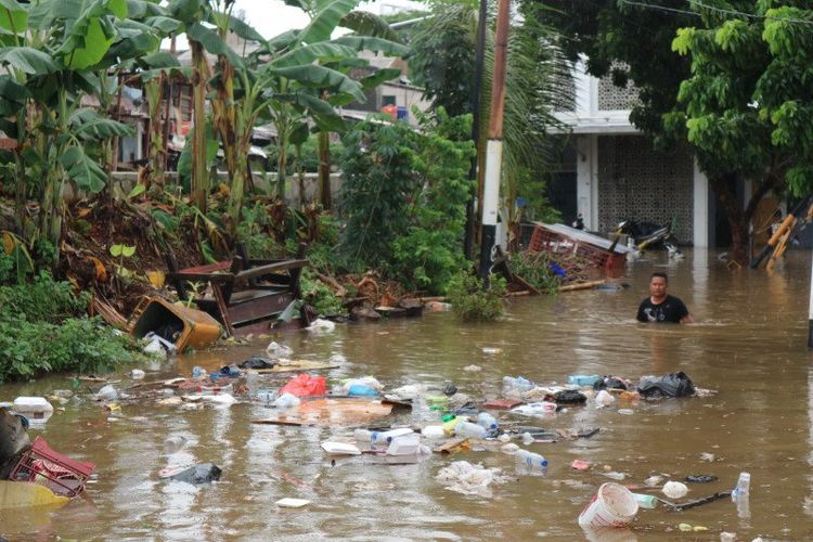 Seorang warga melintasi banjir di Jalan Pondok Jaya, Kelurahan Pela Mampang, Kecamatan Mampang Prapatan, Jakarta Selatan, Rabu (1/1/2020).