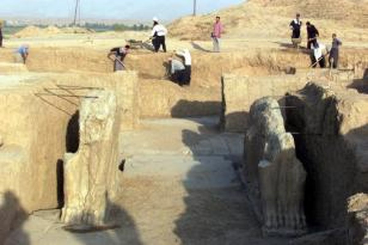 Foto ini diambil pada Juli 2001 memperlihatkan para pekerja senang membersihkan situs arkeologi Nimrud di dekat kota Mosul, Irak. Kota Nimrud dibangun pada abad ke-13 SM di masa kejayaan kekaisaran Assiria.