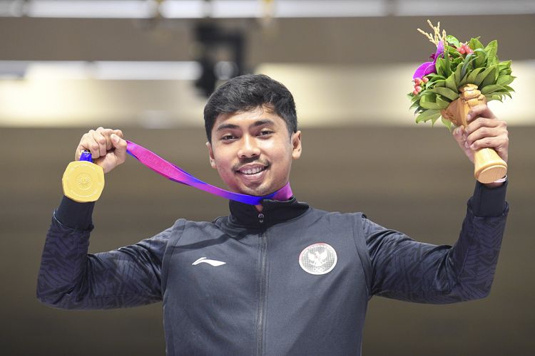 Petembak tunggal putra Indonesia Muhammad Sejahtera Dwi Putra berpose dengan medali emasnya usai upacara penghargaan pemenang final 10 meter running target  Asian Games 2022 di Fuyang Yinhu Sports Centre, Hangzhou, China, Senin (25/9/2023). Muhammad Sejahtera Dwi Putra berhasil mempersembahkan medali emas pertama untuk Indonesia usai mencatatkan poin total poin 578. Artikel ini berisi daftar atlet Indonesia peraih medali Asian Games 2022. ANTARA FOTO/M Risyal Hidayat/aww.