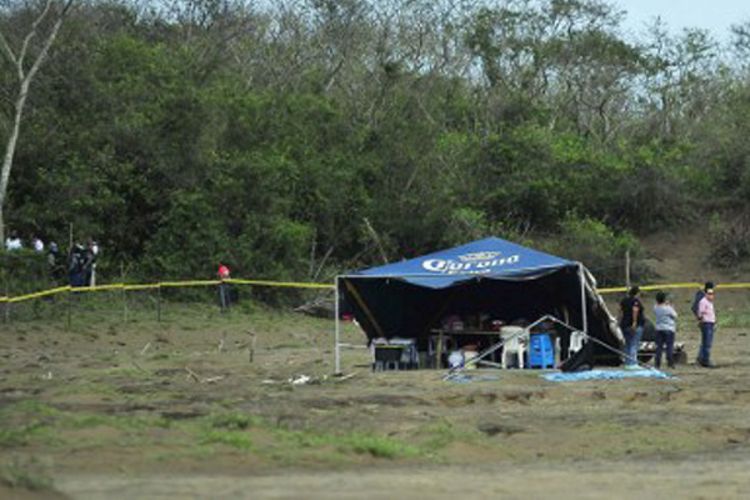 Keluarga korban dan petugas penyidik berkumpul di sisi lahan yang menjadi kuburan massal di pinggiran Kota Veracruz, Negara bagian Veracruz State, Meksiko, 16 Maret 2017.  Setidaknya 242 mayat ditemukan di dalam 124 lubang.  