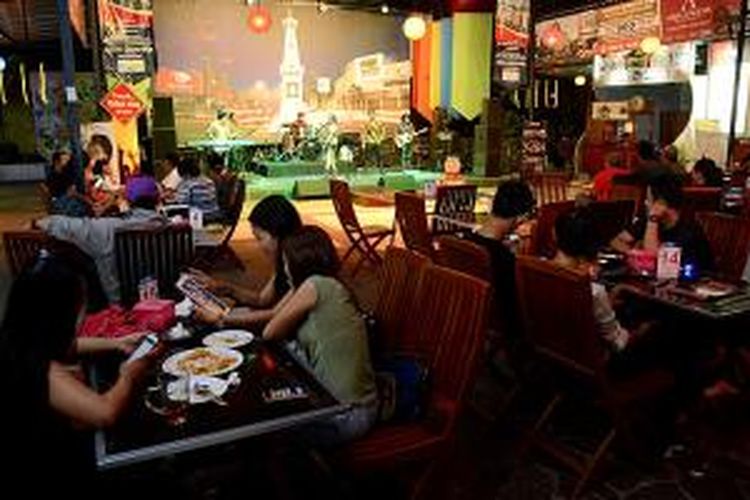 Pengunjung menikmati suasana di Warung Kampayo (Keluarga Musisi, Penyanyi, dan Artis Panggung Yogyakarta) di kompleks XT Square, Yogyakarta, Jumat (20/11/2015) malam. Pengunjung dapat menikmati sajian pertunjukan musik sambil menyantap bermacam hidangan di tempat itu.