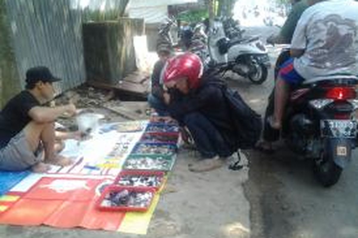 Heri sedang melayani para pembeli batu akik di Jalan Bango Raya, Pondok Labu, Cilandak, Jakarta, Senin (4/8/2014).