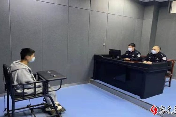 Seorang tersangka  berbicara dengan polisi setelah dituduh mencuri ponsel di Siyang, Provinsi Jiangsu, China.