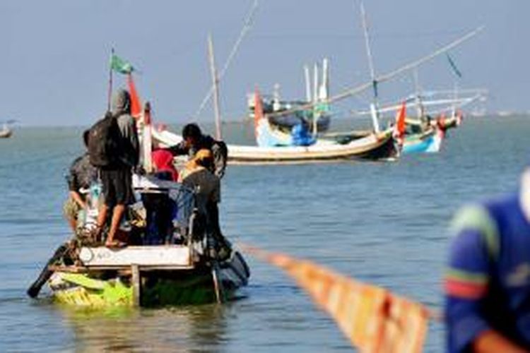 Warga pesisir selatan Pamekasan, Jawa Timur, mudik menggunakan perahu motor walaupun harus kumpul dengan sapi.