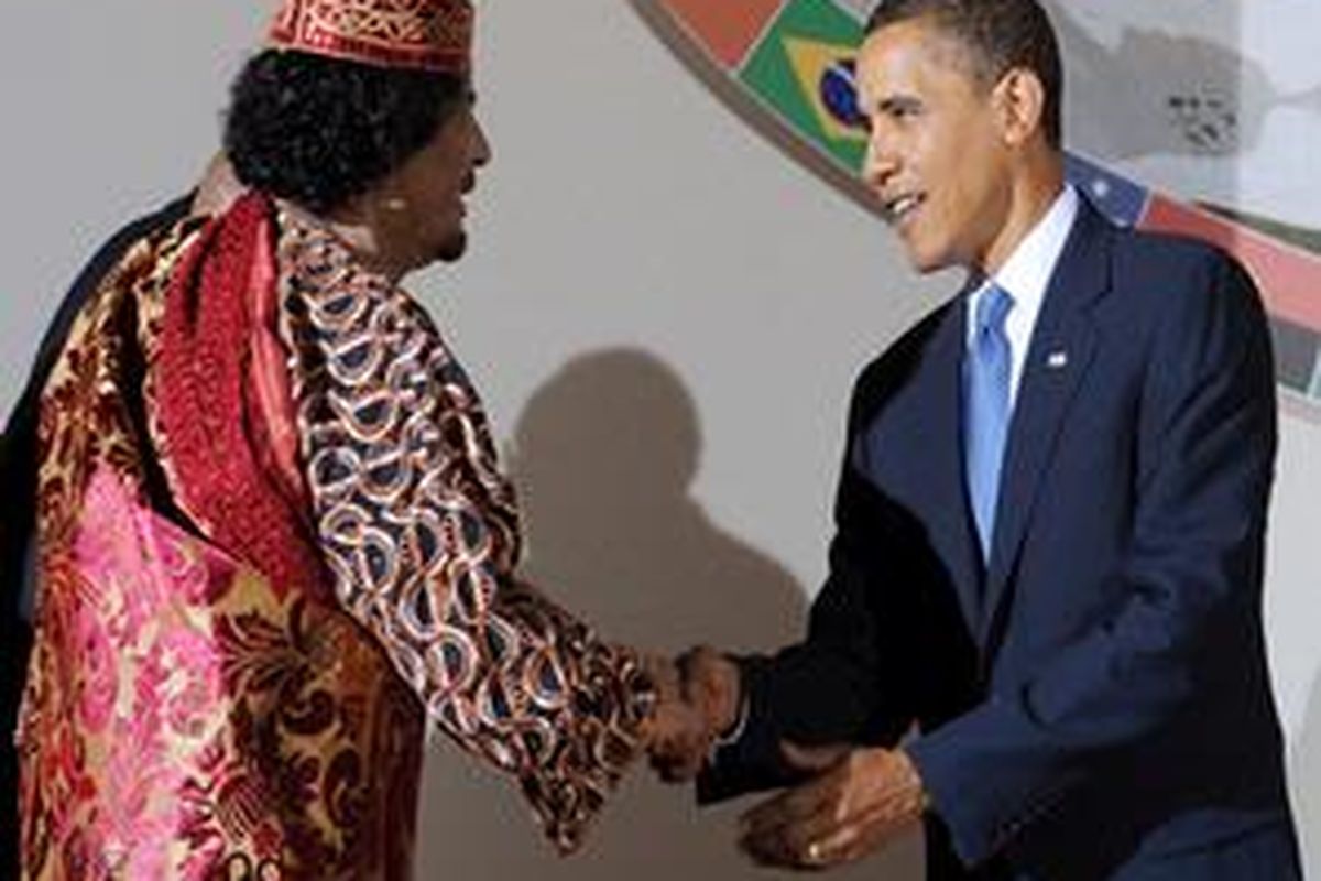Pemimpin Libya Moammar Khadafi (kiri) berjabat tangan dengan Barack Obama.