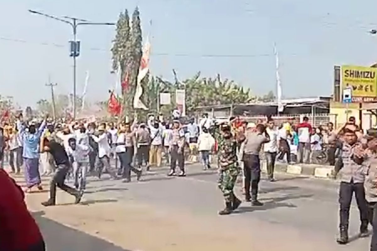 sejumlah warga tampak melakukan aksi pelemparan batu di jalur utama Pantura Desa Kapetakan, saat proses pengambilan nomor urut calon kepala desa Kapetakan, Kabupaten Cirebon, Jawa Barat,pada Senin pagi (18/9/2023)