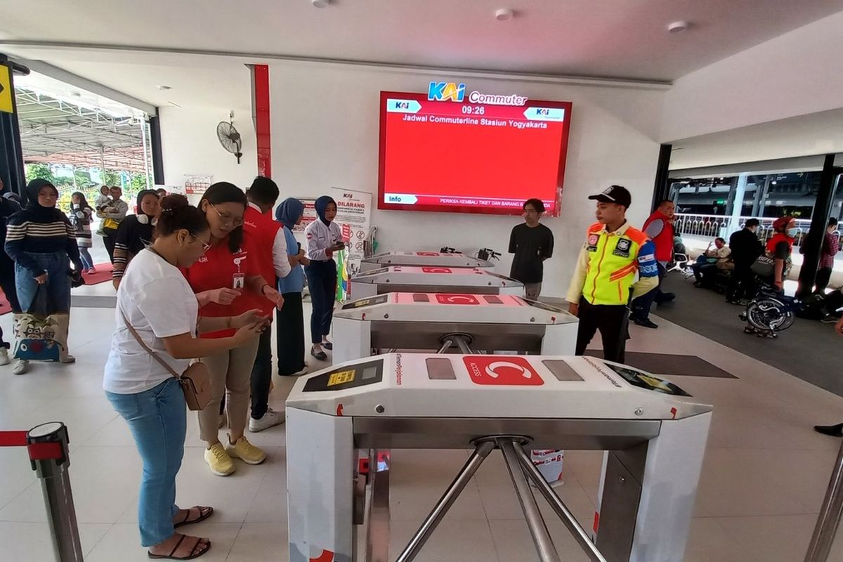Petugas KAI Commuter saat mengarahkan penumpang di hall timur Stasiun Yogyakarta, Sabtu (23/12/2023)