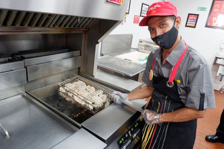 Restianto bersiap menggoreng ayam di restoran McDonald's tempatnya bekerja.