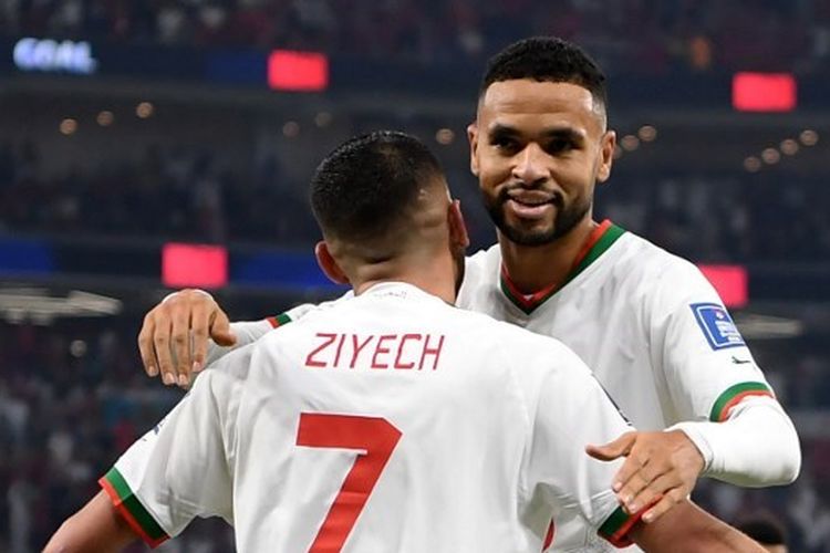 Pemain timnas Maroko, Youssef En-Nesyri dan Hakim Ziyech (7), merayakan gol ke gawang Kanada pada laga Grup F Piala Dunia 2022 Qatar yang digelar di Stadion Al Thumama, Doha, pada 1 Desemner 2022. (Photo by Natalia KOLESNIKOVA/AFP)