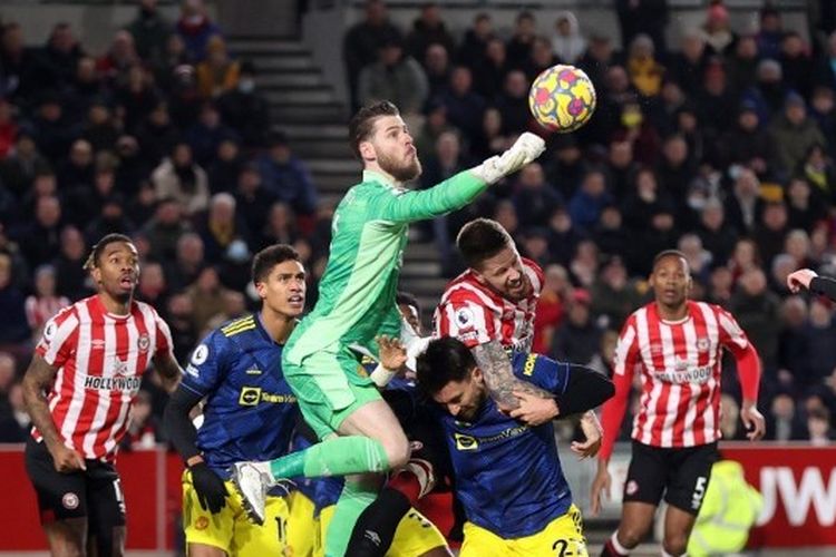 Kiper Man United David De Gea meninju bola dalam laga lanjutan Liga Inggris musim 2021-2022 kontra Brentford di Stadion Brentford Community, Kamis (20/1/2022) dini hari WIB.