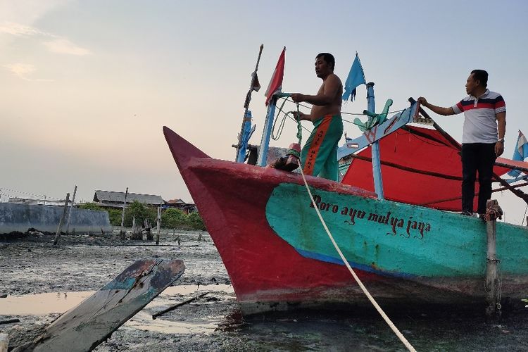 Ketua HNSI Jawa Tengah Riswanto dan seorang nelayan mengecek kapal yang kandas di Sungai Kali Bacin, Kota Tegal, Jawa Tengah, Rabu (5/1/2022). 
