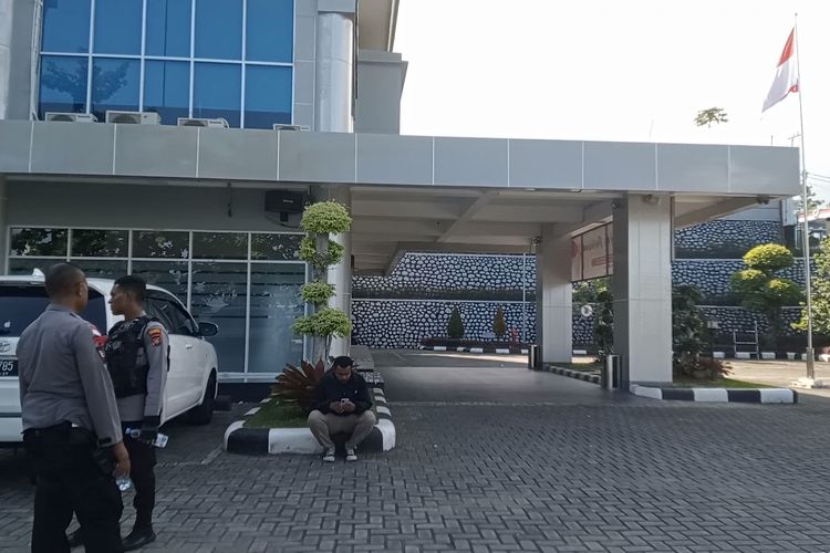 Dua personel polisi berada di halaman kantor BPK Papua Barat mengawal tim penyidik KPK melakukan penggeledahan 