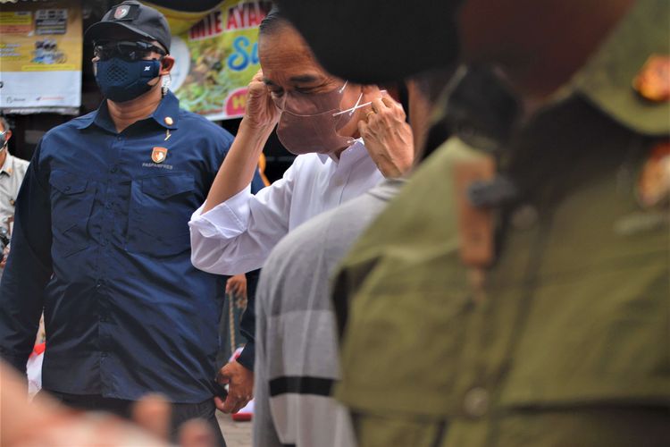 Suasana kunjungan Presiden Joko Widodo di Pasar Umum Kota Purwodadi, Kabupaten Grobogan, Jawa Tengah, Rabu (5/1/2022) pagi. Dalam kunjungan kerja di pasar rakyat yang berlokasi di pusat kota tersebut, Jokowi membagikan sebanyak 500 paket sembako dan 125 amplop masing-masing berisi uang tunai Rp 1,2 juta kepada pedagang.