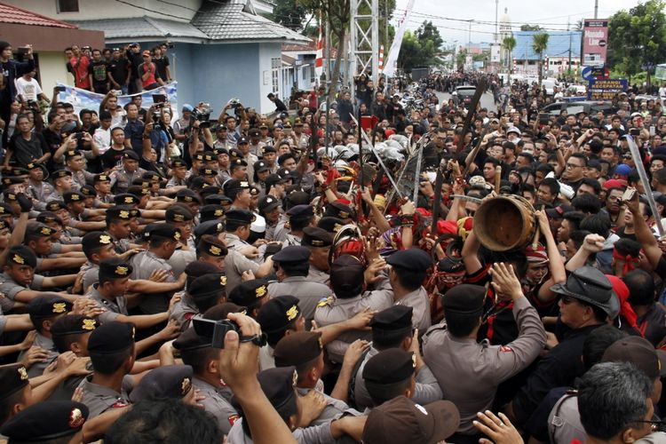 Massa berhadap-hadapan dengan barikade polisi di depan pintu masuk halaman VIP Bandara Sam Ratulangi Manado dalam aksi menolak kedatangan Fahri Hamzah di Sulut, Sabtu (13/5/2017). Fahri Hamzah dianggap sebagai sosok yang sering mengumbar pernyataan yang memicu tindakan intoleran.