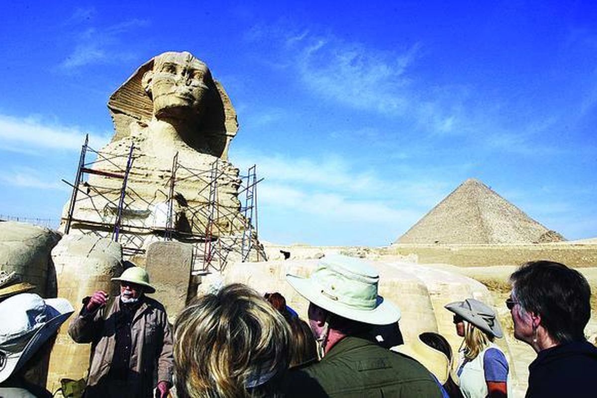 Wisatawan mendengarkan penjelasan sejarawan di depan Sphinx di Giza, obyek wisata paling populer di Mesir, Rabu (9/2). Kompleks Piramid Giza, lokasi yang paling menarik perhatian wisatawan di Mesir, dibuka kembali untuk umum mulai Rabu, dua pekan setelah demonstrasi antipemerintah berlangsung. Puluhan ribu warga asing meninggalkan Mesir karena kerusuhan tersebut, menimbulkan keprihatinan soal dampak ekonomi dari unjuk rasa itu.