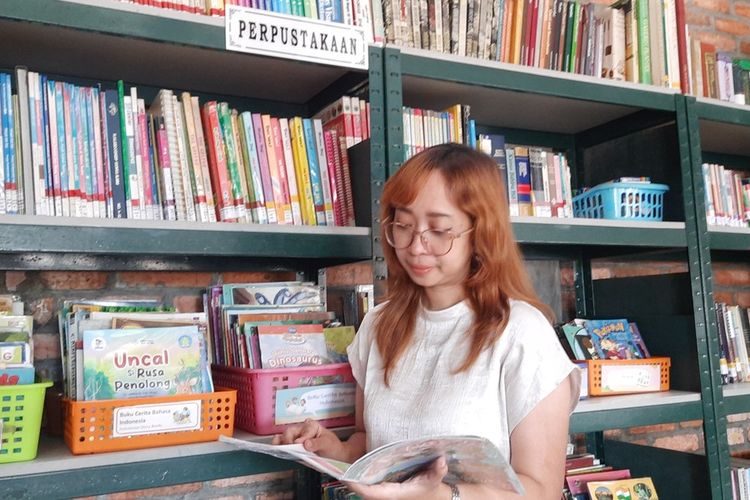 Sitta Alia, pustakawan perempuan di Kabupaten Bogor, Jawa Barat. Ia tampak sibuk menyusun buku di setiap rak.