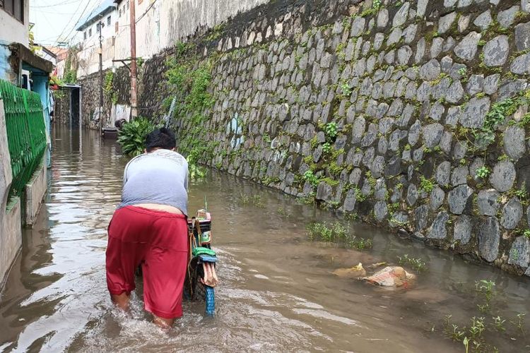 Salah seorang warga saat menerjang banjir di Gang Cue, Jalan Ir Juanda, Duren Jaya, Bekasi Timur, Kota Bekasi, Jumat (3/3/2023). Diketahui, banjir tersebut sudah berlangsung selama kurang lebih 3 tahun.
