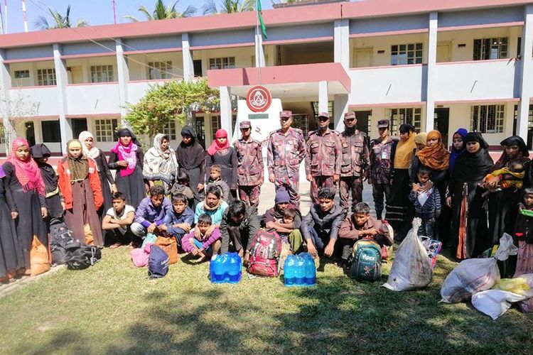 Sejumlah pengungsi Rohingya yang diselamatkan berfoto bersama petugas di kamp penjaga perbatasan Bangladesh di Teknaf.