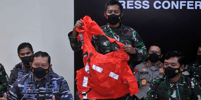 Indonesia Military (TNI) commander Air Chief Marshal Hadi Tjahjanto (right) and Navy chief of staff Admiral Yudo Margono (left) showing an escape suit in orange color belongs to the sailors of KRI Nanggala 402 submarine during a press conference in Bali, Sunday, April 25, 2021. 