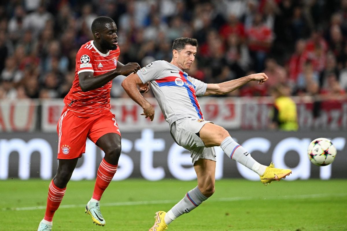 Robert Lewandowski berebut bola dengan Dayot Upamecano dalam pertandingan Bayern Muenchen vs Barcelona pada fase Grup C Liga Champions 2022-2023 di Allianz Arena, Rabu (14/9/2022) dini hari WIB. (Foto AFP/CHRISTOF STACHE)