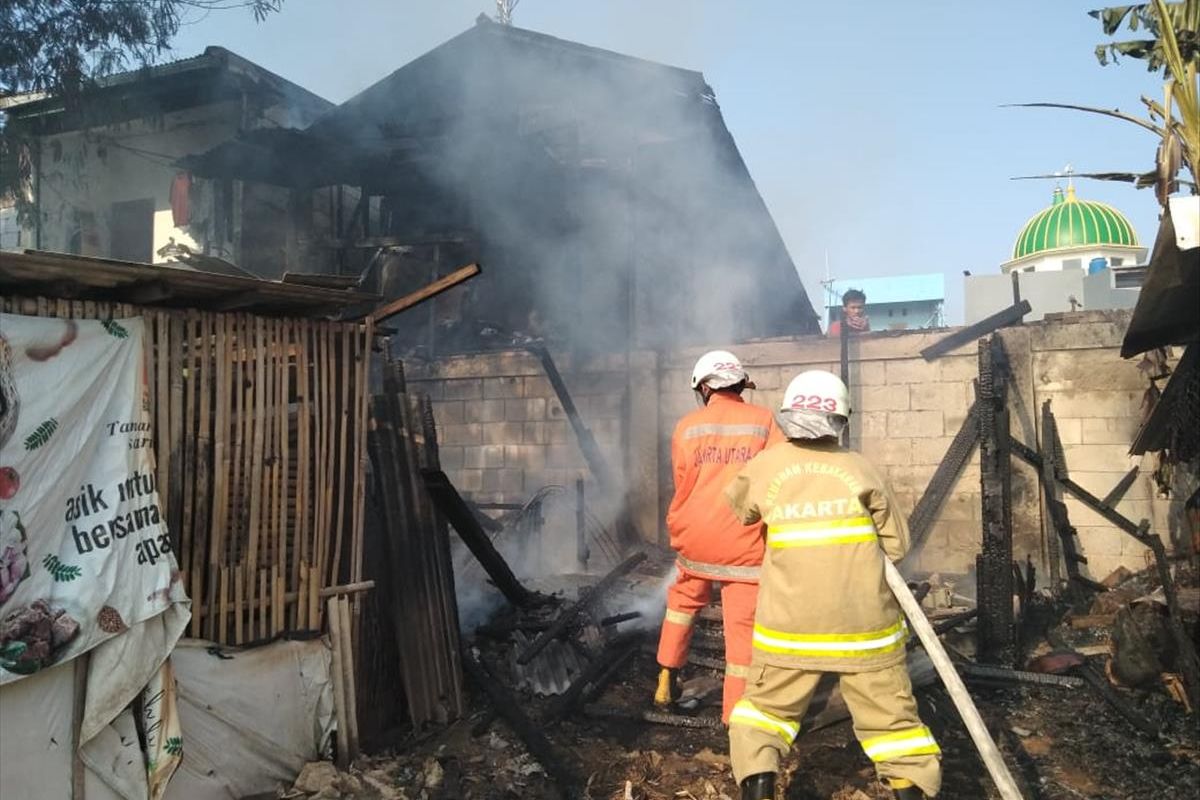 Petugas berjibaku memadamkan api yang melalap rumah semipermanen di Perintis Kemerdekaan, Kelapa Gading, Jakarta Utara Rabu (5/6/2019).