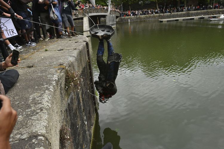 Demonstran membuang patung Edward Colston di pelabuhan Bristol, dalam lanjutan demonstrasi Black Lives Matter di Inggris, Minggu (7/6/2020). Demonstrasi ini dipicu oleh tewasnya pria keturunan Afrika-Amerika George Floyd, yang lehernya ditindih lutut polisi selama hampir 9 menit di Minneapolis, Amerika Serikat, 25 Mei 2020. Kematiannya yang mengenaskan memicu rangkaian demonstrasi besar, tidak hanya di hampir seluruh penjuru AS tapi juga negara-negara lain.