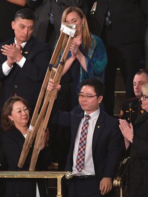 Pembelot Korea Utara Ji Seong-ho mengangkat kruknya saat disebutkan oleh Presiden AS Donald Trump pada pidato kenegaraan, di Washington DC, Selasa (30/1/2018) (AFP/Mandel Ngan)