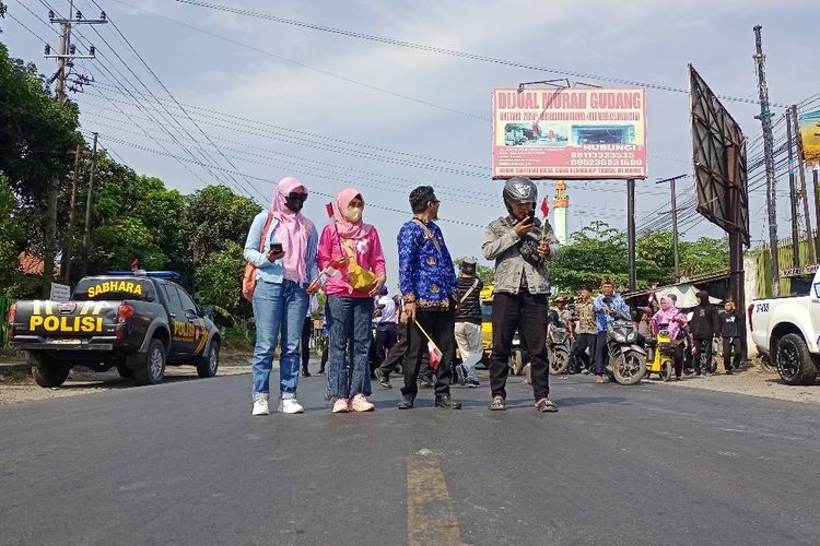 Anita (paling kiri) dan ratusan pengendara berhenti sejenak mengheningkan cipta mengenang jasa para pahlawan di Jalur Pantura Kecamatan Pajarakan, Kabupaten Probolinggo, Jawa Timur, Jumat (10/11/2023). 