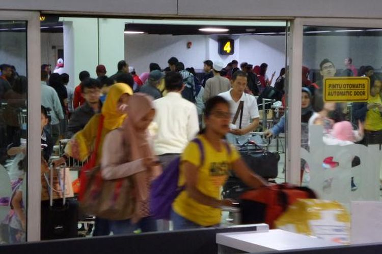 Sejumlah penumpang pesawat keluar dari pintu kedatangan Terminal 1B Bandara Soekarno-Hatta, Senin (11/7/2016) malam. Penumpang yang baru tiba memenuhi bandara setelah melakukan perjalanan libur panjang saat Lebaran 2016.