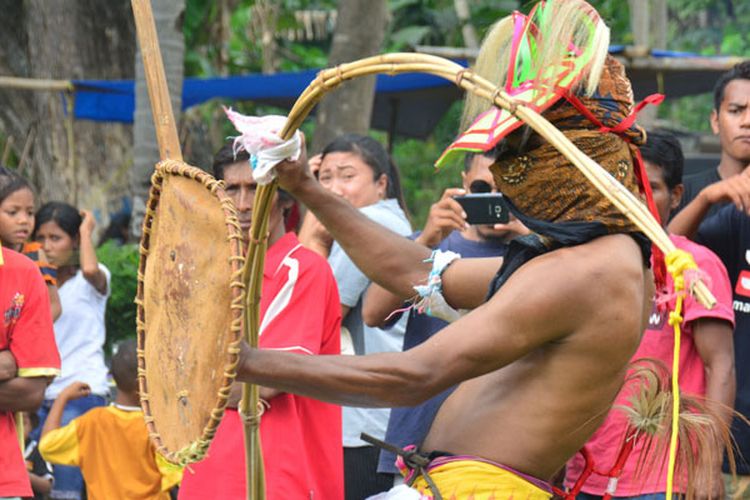 Seorang petarung dari Desa Rende sedang menangkis pukulan dari lawannya dari Desa Gunung pada atraksi budaya tarian Caci untuk memeriahkan HUT ke-72 RI di halaman Kantor Kecamatan Kota Komba, Manggarai Timur, Flores, Nusa Tenggara Timur, Rabu (16/8/2017). Atraksi budaya Caci terus dipentaskan di wilayah Manggarai Timur sebagai tarian khas yang diwariskan leluhur. 