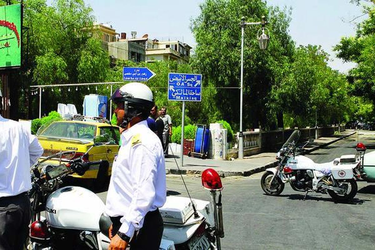 Polisi Suriah berjaga di jalan dekat lokasi ledakan bom di Markas Besar Biro Keamanan Nasional di Rawda, distrik yang dijaga ketat di pusat kota Damaskus, Rabu (18/7). Menteri Pertahanan Suriah Jenderal Dawoud Rajha dan kakak ipar Presiden Bashar al-Assad, Jenderal Assef Shawkat, tewas dalam insiden tersebut.   
