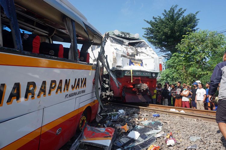 Warga melihat dari dekat kondisi bus dan lokomotif KA Rapih Dhoho yang rusak berat usai tabraka maut di perlintasan kereta api tanpa palang pintu di Desa Ketanon, Tulungagung, Jawa Timur, Minggu (27/2/2022). Kecelakaan yang terjadi sekitar pukul 05.00 WIB itu menyebabkan lima dari 43 penumpang termasuk awak bus meninggal dunia dan 14 lainnya luka-luka dan harus dilarikan ke RSUD dr. Iskak Tulungagung untuk mendapat pertolongan kedaruratan medis.