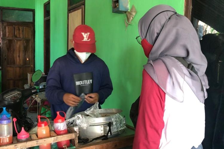 LAYANI PEMBELI-- Abi Rizal Mandani (14), warga Kelurahan Beduri, Kecamatan Ponorogo, Kabupaten Ponorogo, Jawa Timur melayani pembeli pentol dan batagor. Siswa kelas 9 SMP ini berjualan pentol keliling menggantikan ayahnya yang meninggal akibat covid-19 bulan lalu.