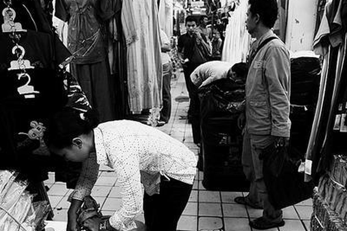 Pekerja mengepak pakaian yang dipesan pelanggannya di salah satu kios di Pasar Cipulir, Jakarta Selatan, Juni lalu. Para pedagang meminta pemerintah membatasi pasar modern agar tidak mematikan pasar-pasar tradisional.