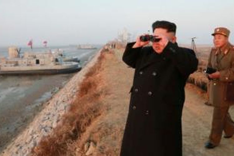 Pemimpin Korea Utara Kim Jong Un menggunakan teropong untuk memantau pergerakan pasukan dalam sebuah latihan militer.