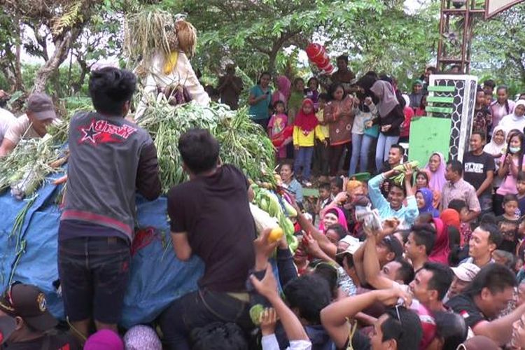 Warga berebut hasil bumi yang dipasang pada gunungan yang diarak dalam tradisi Syawalan di Boja, Kendal, Jawa Tengah, Selasa (17/7/2016).