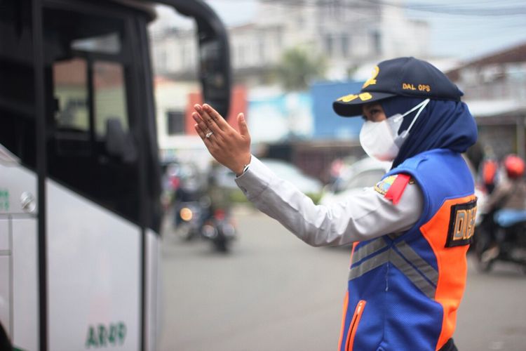 Seorang petugas tengah mengatur lalu lintas kendaraan di kawasan tugu Lampu Gentur Cianjur, Jawa Barat, pada momen mudik lebaran 2022.