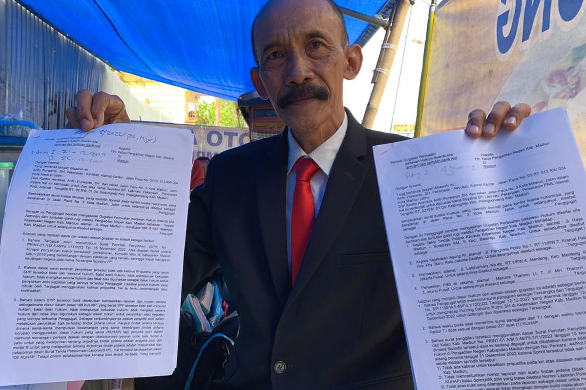 MATERI GUGATAN—Kuasa hukum tersangka kasus dugan korupsi penyaluran pupuk bersubsidi, Suyatno, Arifin Purwanto menunjukkan materi gugatan terhadap Kepala Kejaksaan Negeri Kabupaten yang di Pengadilan Negeri Kabupaten Madiun, Kamis (23/12/2022).