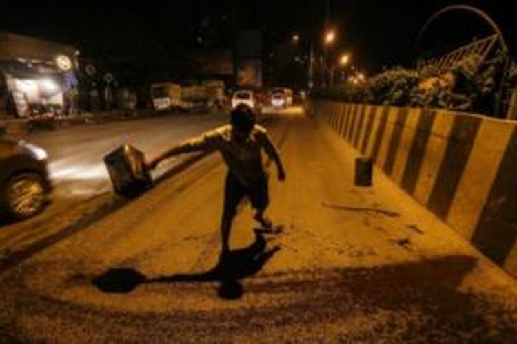 Seorang pekerja tengah melakukan perbaikan jalan di kota Mumbai, India. Pengadilan tinggi Mumbai memutuskan mendapatkan jalan raya dengan kondisi baik adalah hak dasar warga negara.