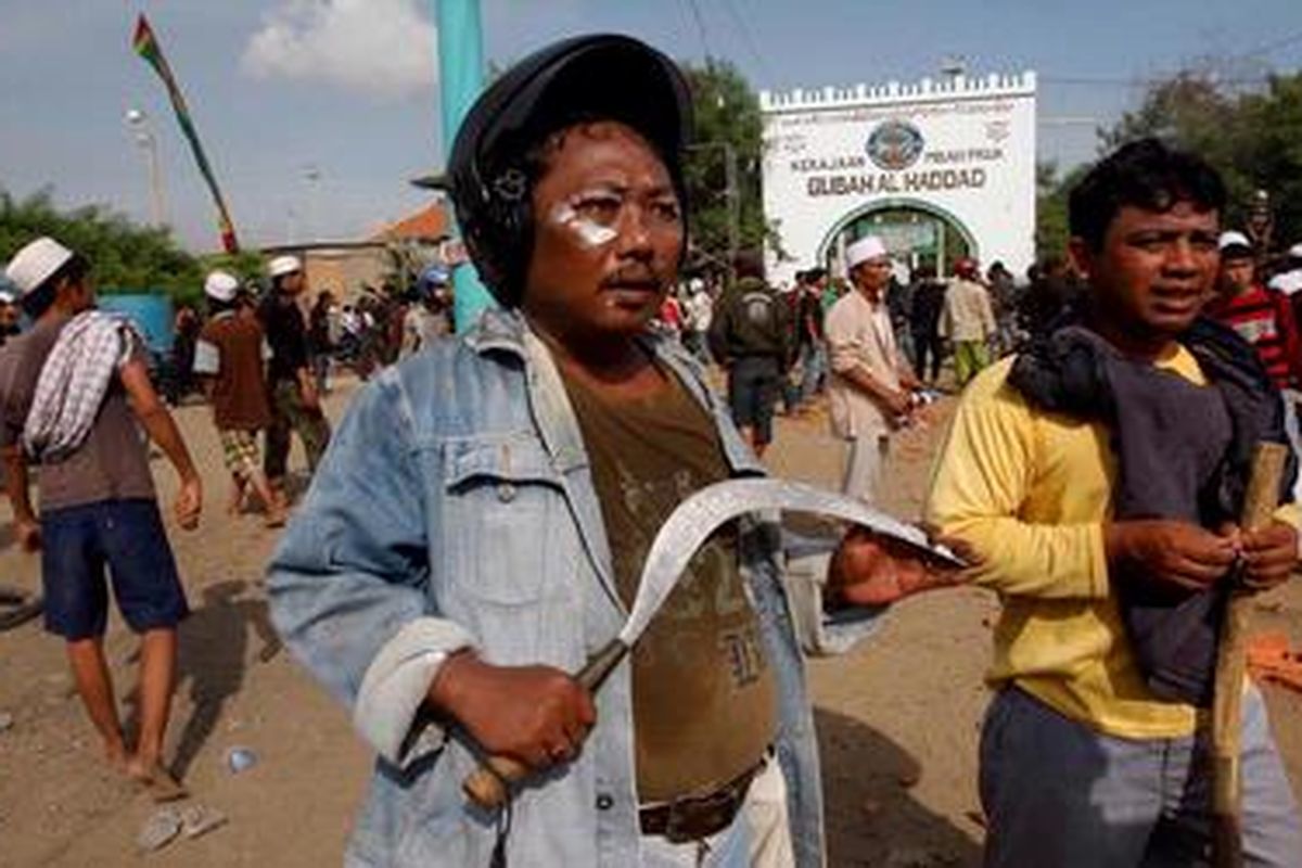 Warga mempersenjatai diri dengan senjata tajam saat terlibat bentrok dengan satpol PP dalam upaya pembongkaran kompleks makam Mbah Priok di Tanjung Priok, Jakarta, Rabu (14/4/2010). 