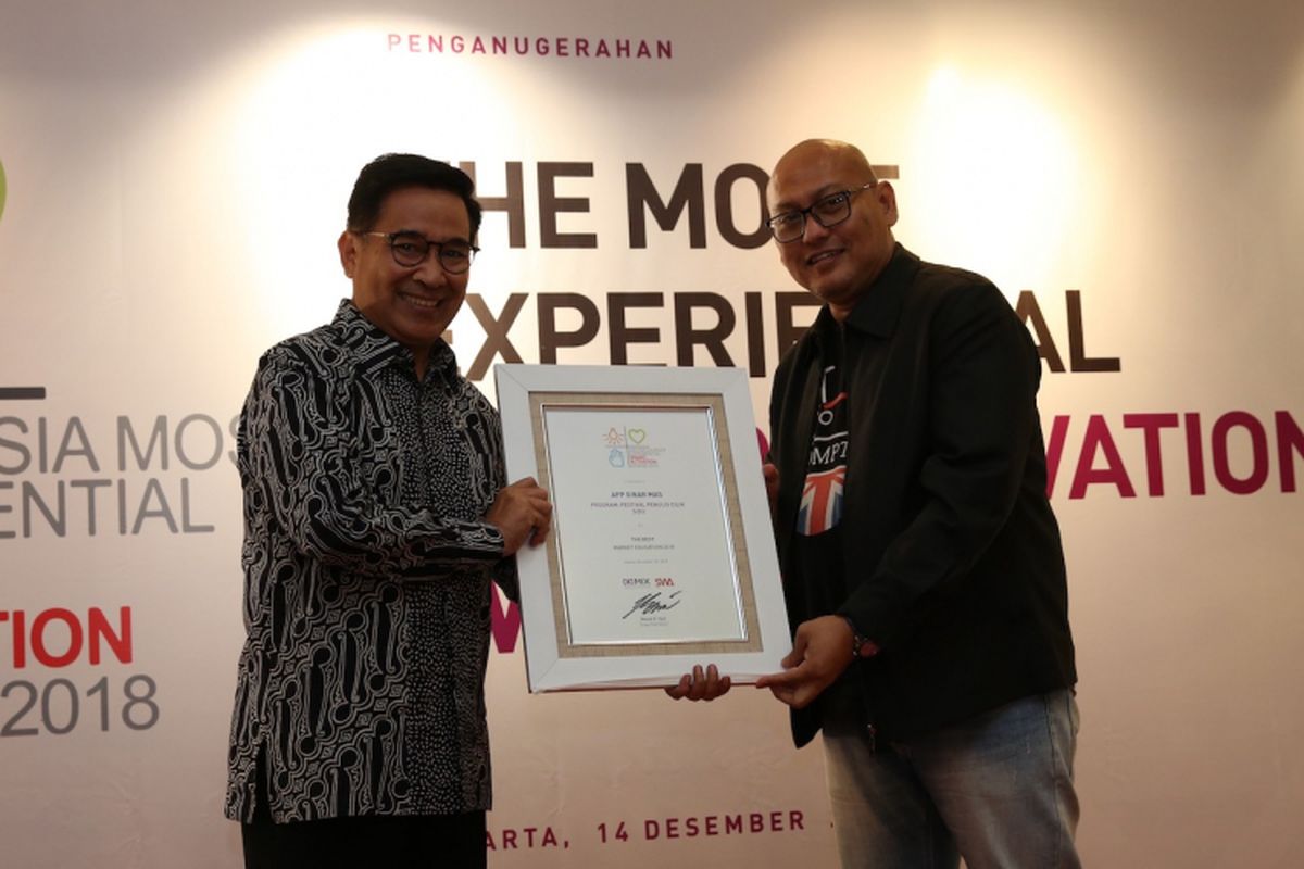 Deputy Director Corporate Affairs APP Sinar Mas Irsyal Yasman menerima penghargaan kategori Edukasi Pasar Terbaik untuk program Festival Penulis Cilik SiDU dari Adi Wijaya selaku anggota Dewan Juri di ajang The Most Experiential Brand Activation Award 2018.