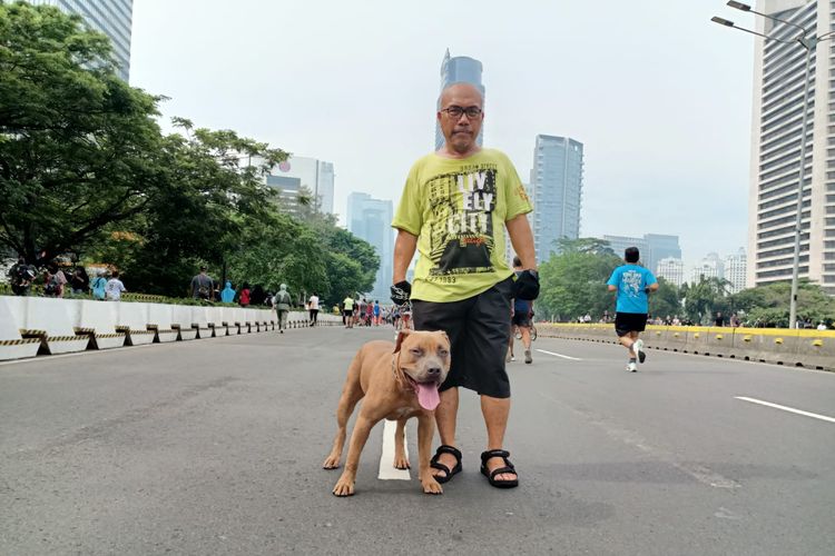 Ketua Forum Warga Kota Jakarta (Fakta) Azas Tigor Nainggolan bersama Alpen, anjing kesayangannya, saat berfoto di area car free day, Minggu (10/10/2022).