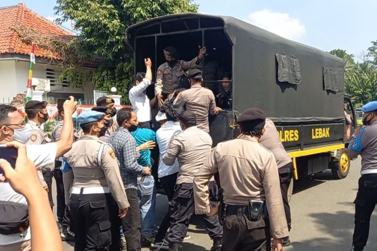 Sejumlah peserta aksi diamankan saat menggelar aksi menolak PPKM di Alun-alun Rangkasbitung, Kabupaten Lebak, Senin (26/7).