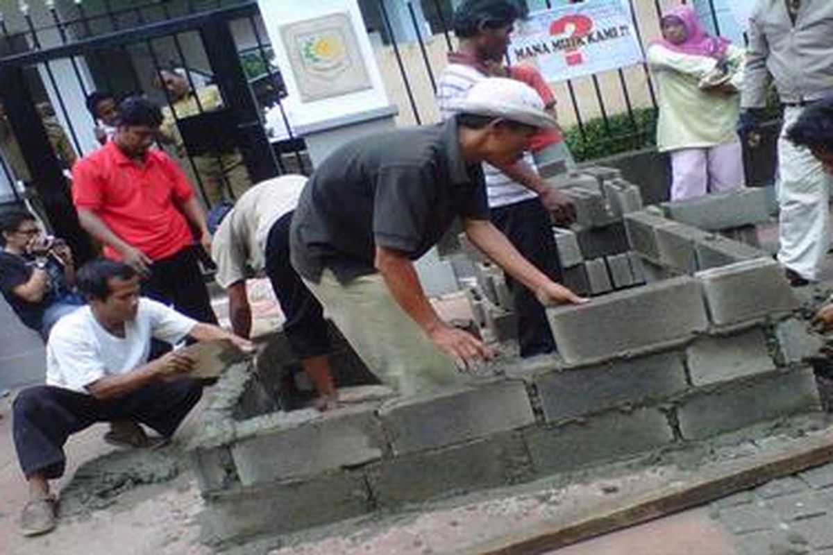 Foto ini diambil ketika Sejumlah warga Tanah Merah sedang membangun WC permanen di depan gerbang masuk Kemendagri, Senin (6/2/2012). Mereka sudah berunjuk rasa sebulan untuk menuntut dibuatkan KTP dan diakui sebagai warga Jakarta.