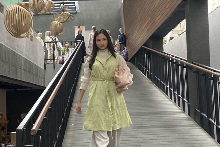 Model mengenakan dress tanpa lengan berwarna hijau pastel dengan motif floral pada acara anniversary Merché di Kopitagram Centang Biru, Kuningan, Jakarta Selatan, Jumat (7/2/2025).