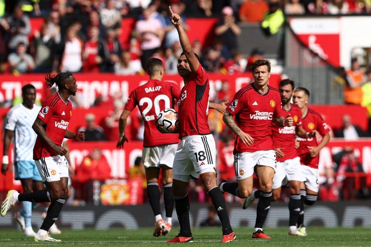 Gelandang Manchester United asal Brasil, Casemiro (nomor 18), merayakan gol ke gawang Nottingham Forest. Laga Man United vs Nottingham Forest yang digelar di Stadion Old Trafford pada Sabtu (26/8/2023) waktu setempat tersebut berakhir dengan kemenangan 3-2 tim tuan rumah. Man United selanjutnya melawan Bayern Muenchen pada fase Grup A Liga Champions. Artikel ini berisi jadwal Liga Champions. (Foto oleh Darren Staples / AFP)